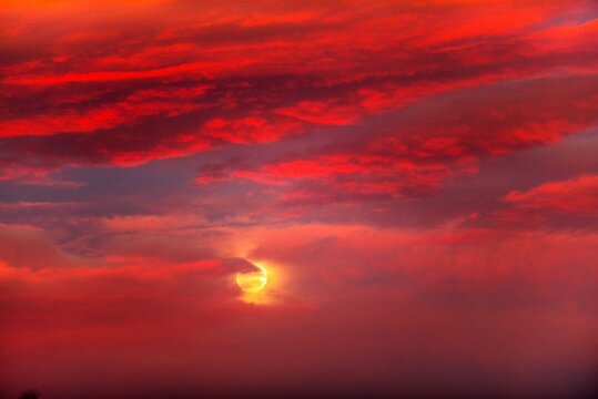 The moon behind red cloud at sunset in the Atacama desert, Chile. 