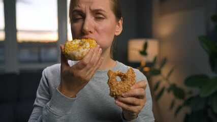 Binge eating concept. Caucasian woman with eating disorder eating two donuts quickly and at the same time.
