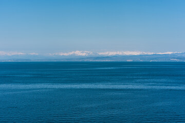 Blue seascape in minimalistic style with the mountains in the background in Piran, Slovenia