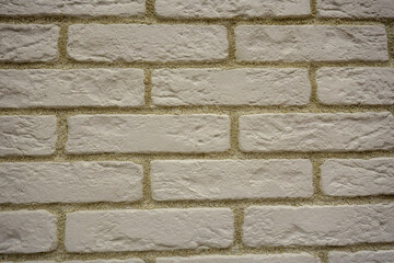 Wall of white uneven bricks with a yellowish seam.