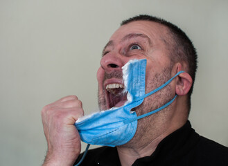 Man tired of wearing the mask rips it off
