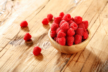 Raspberries on a wooden table on a beautiful sunny day 