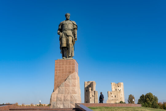 Uzbekistan, city of Chakhrisabz (old Kech) Bronce statue of Amir Timur.   In the background the ruins of the gate to Ak Saray Palace,  