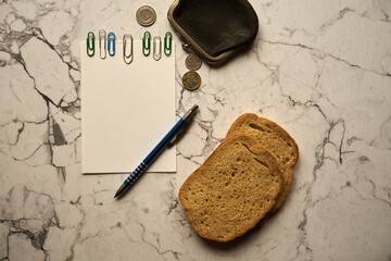 pusta kartka ,czarna portmonetka ,kromki chleba na  marmurowym blacie,polski złoty	