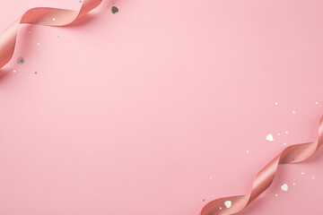 Top view photo of saint valentine's day decorations curly silk ribbon shiny sequins and heart shaped confetti on isolated pastel pink background with copyspace