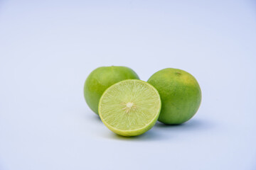 Whole green lime citrus fruit with lime half on white background
