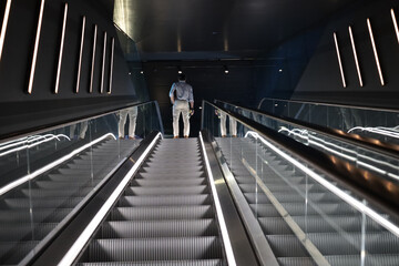 Back view of a male on an illuminated escalator