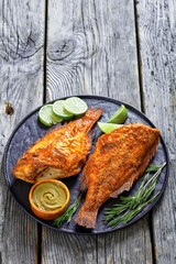 two fried ocean perch with rosemary and lime
