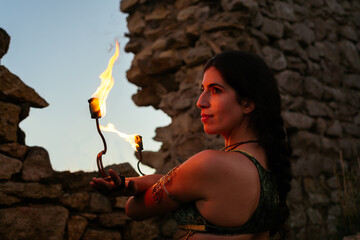 Woman with fire fans in evening