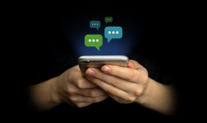 E-mail and social media. Hands using smartphone with new messages icon. Business and marketing concept, black background photo