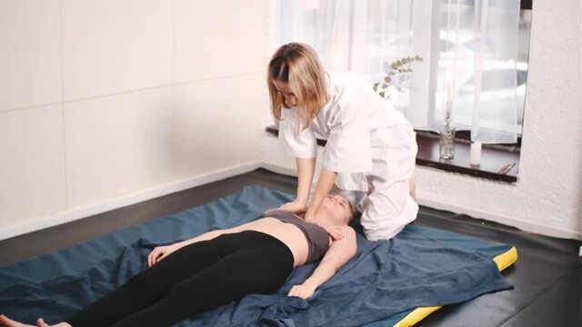 Masseur makes chinese massage of neck and decollete of woman in clinic
