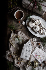 Holiday preparations. wrapping the presents. Meringue cookies with chocolate and almond cream ,cup of hot chocolate and natural winter decorations on old wooden table 