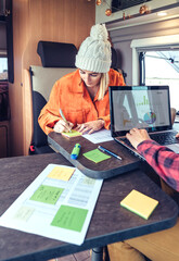 Woman and man telecommuting during a camper van trip
