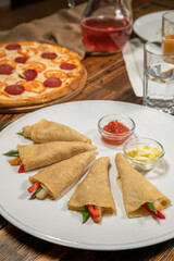 An appetizer - pancakes with vegetables, molasses and caviar.