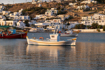 Greek fishing boat in Mykonos island old harbor, Chora town buildings background Cyclades, Greece