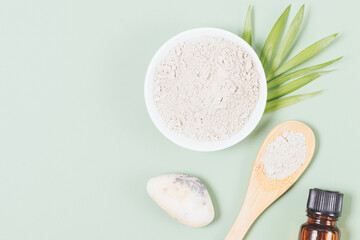 Natural cosmetic clay powder next to essential oil