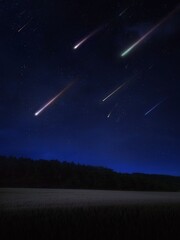 Falling meteorites. Beautiful meteor shower in the night sky over fields and forests. Night landscape with stars and comets.