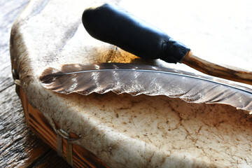 A low angle image of a handmade meditation drum with sacred feather. 