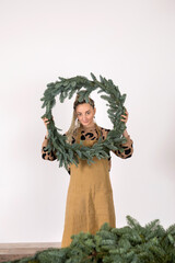 DIY Christmas composition from nobilis. Wreath decor for holiday decorations. Girls at a workshop on making floristry from tree branches