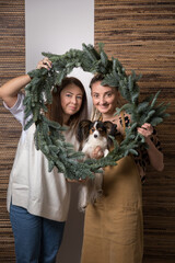 DIY Christmas composition from nobilis. Wreath decor for holiday decorations. Girls at a workshop on making floristry from tree branches