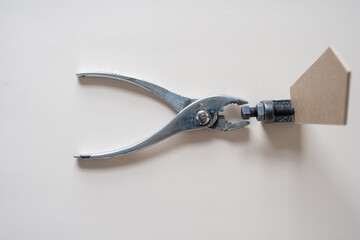 pliers with metal object and wood