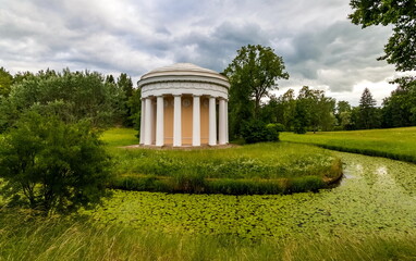 Fototapeta na wymiar Summer landscape in a city Park with trees, pavilion, river, sky with clouds