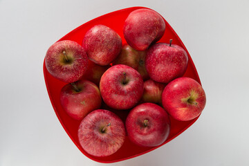 Cesto rosso con mele rosse su superficie chiara