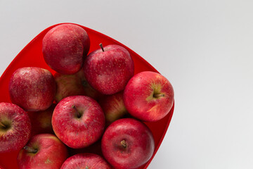 Cesto rosso con mele rosse su superficie chiara