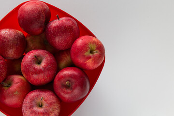 Cesto rosso con mele rosse su superficie chiara