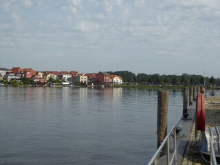 Fototapeta na wymiar Shipping pier and houses in Malchow, Mecklenburg-Western Pomerania, Germany
