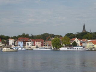 Fototapeta premium View over Lake Malchow to excursion boats and the town of Malchow, Mecklenburg-Vorpommern, Germany