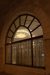 Beautiful chandelier as seen through an arched window at a luxury hotel in Jerusalem, Israel
