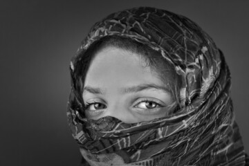 Grayscale shot of a Caucasian female with a headscarf with patterns