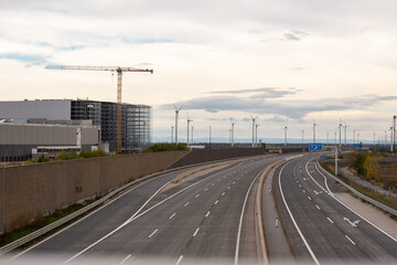 Warehouse under construction without external wall. Metal shelves of a future logistics center. Construction of a steel building, in the foreground a yellow construction crane