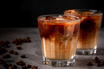 Ice coffee in a glass with cream poured over.