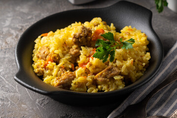 Traditional azian pilaf served in plate on gray background