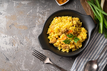 Traditional azian pilaf served in plate on gray background