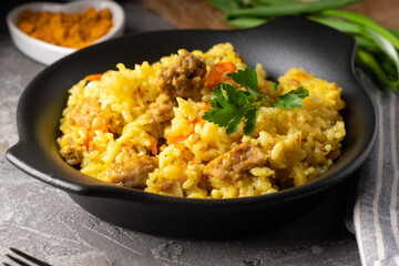 Traditional azian pilaf served in plate on gray background
