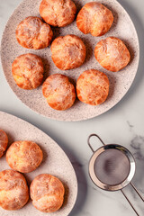 Homemade profiteroles with powdered sugar.