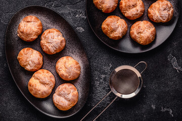 Homemade profiteroles with powdered sugar.