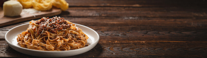 Pasta tagliatelle with BOLOGNESE SAUCE on wooden table with copy space banner © SerPhoto