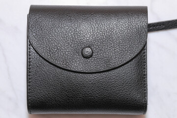 Top view of black genuine leather wallet with banknotes and credit card inside isolated on white background.