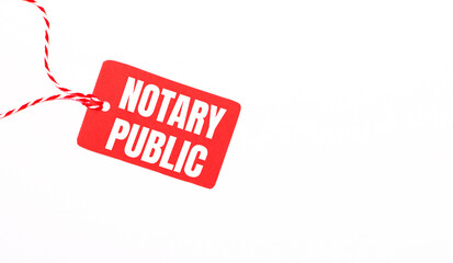 The inscription NOTARY PUBLIC on a red price tag on a light background. Advertising concept. Copy space