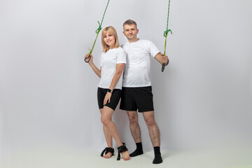 Man and woman. Two happy athletes stand on a light background  and smile .