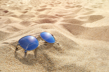 Fototapeta na wymiar Sunglasses in the sand at the beach