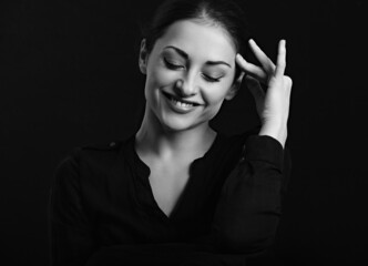 Beautiful business woman with long hair laughing with closed eyes on black background. Closeup portrait