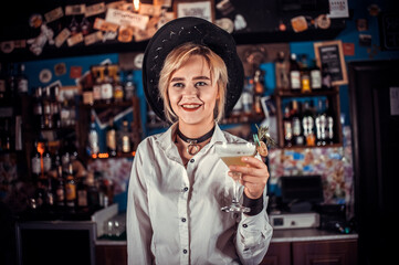 Girl barman concocts a cocktail in the pothouse