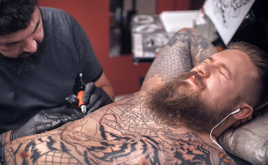Tattoo master working on professional tattoo machine device in tattoo parlor