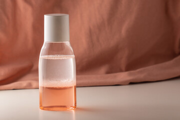 Foamed two-phase make-up remover. Two-phase liquid on a pink background. Bicolor liquid in a...