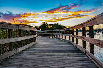 Walkway leading to a spectacular sunset with gold yellow and orange clouds